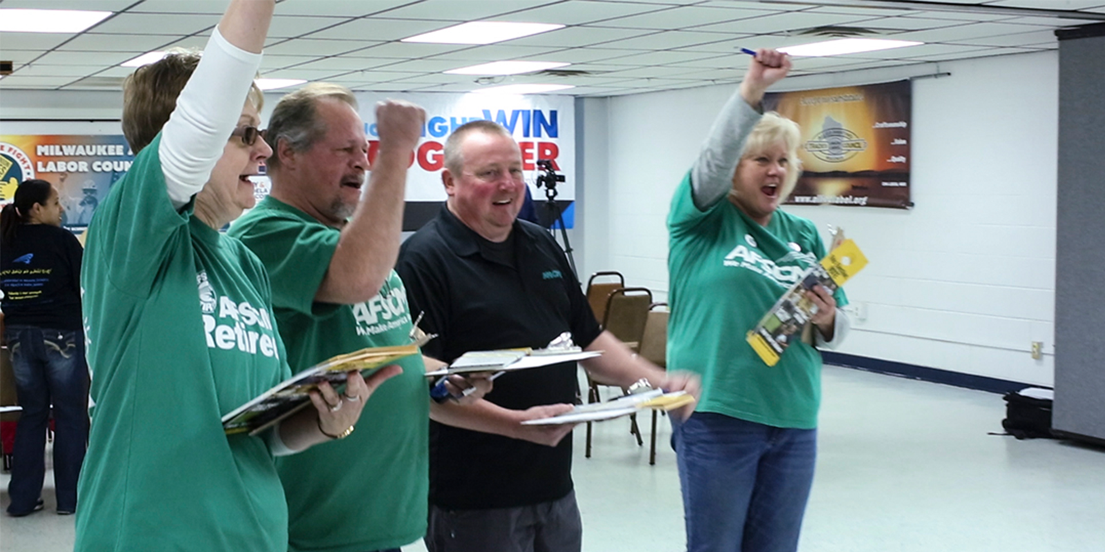 Photograph of two women and two men cheering - presumably for their winning candidate - and all of whom are wearing AFSCME shirts.